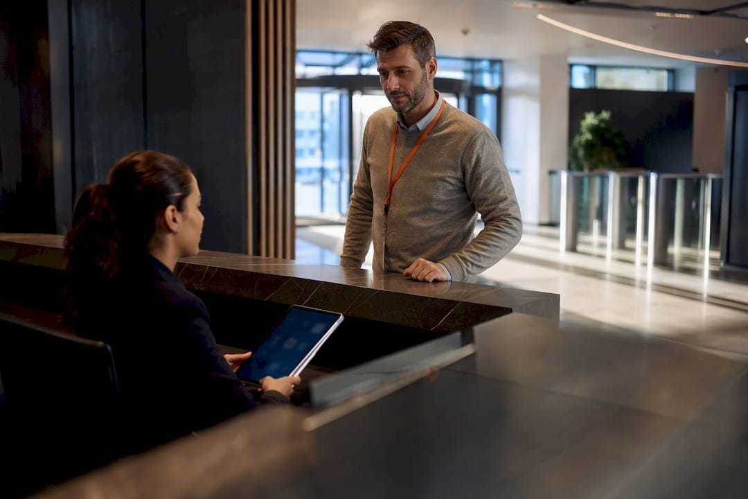 Receptionist verifying visitor at secured front desk