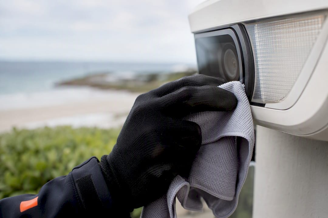 Security Camera Lighting That Stops Glare and Meets Australian Rules 9 Technician cleaning outdoor camera lens