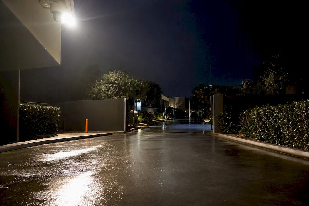 Security light glare reflecting across wet driveway
