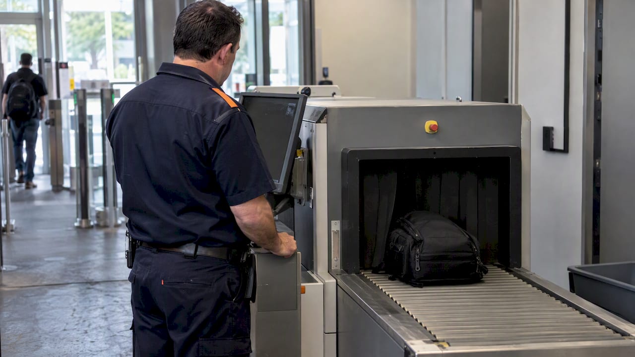 Officer monitoring a bag at an X-ray scanner